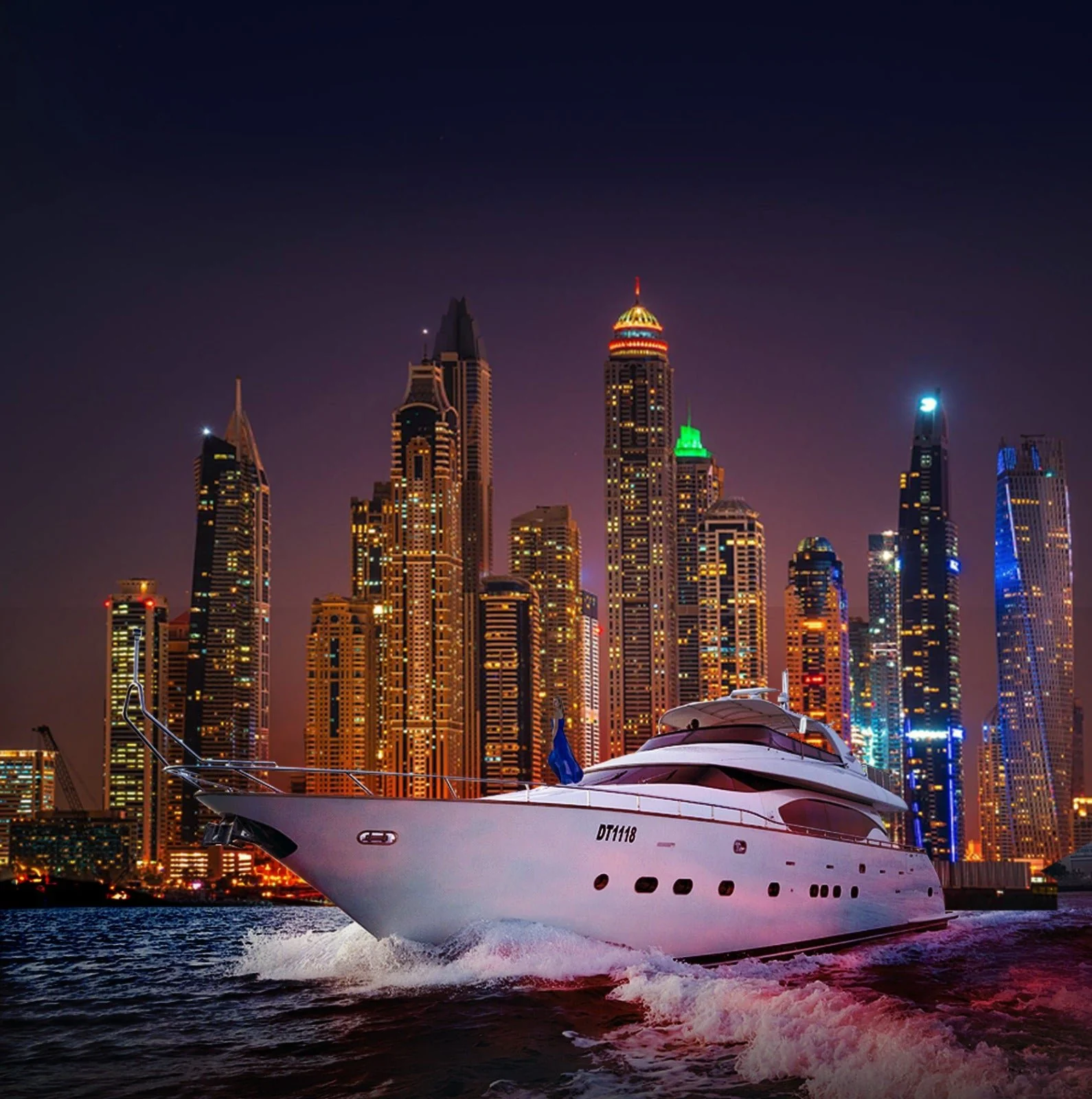 Yacht devant les tours de Dubai Marina, de nuit